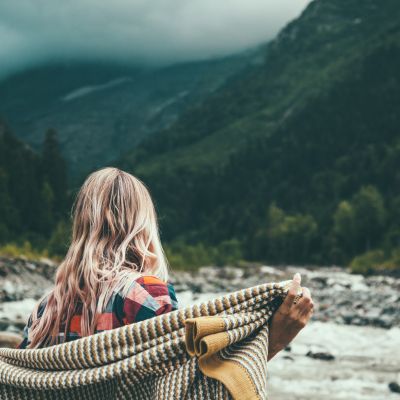woman wrapping herself in soft blanket