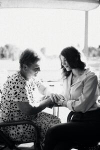 A heartwarming black and white photo capturing a tender moment between a mother and daughter sitting together.